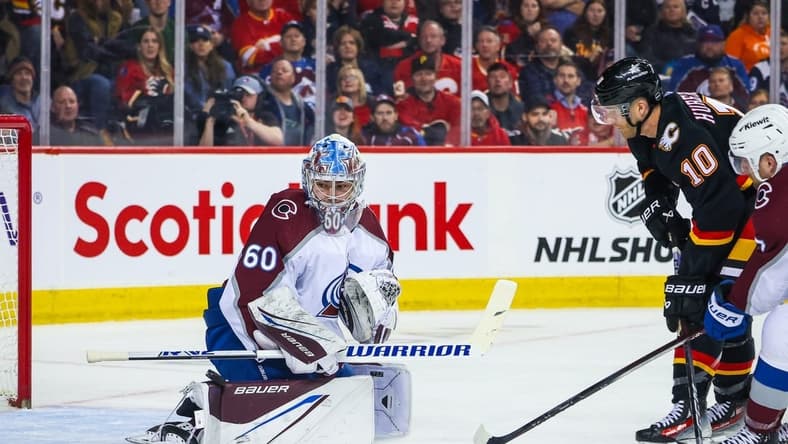 Mar 12, 2024; Calgary, Alberta, CAN; Colorado Avalanche goaltender Justus Annunen (60) makes a save against Calgary Flames center Jonathan Huberdeau (10) during the second period at Scotiabank Saddledome. Mandatory Credit: Sergei Belski-USA TODAY Sports