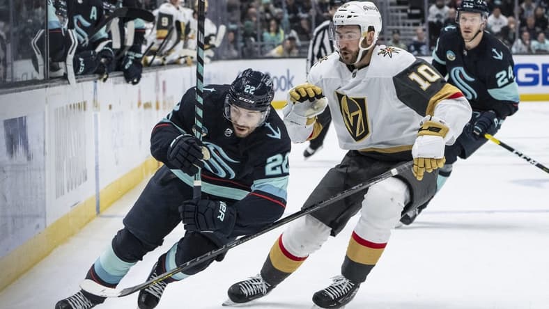Mar 12, 2024; Seattle, Washington, USA; Seattle Kraken forward Oliver Bjorkstrand (22) and Vegas Golden Knights forward Nicolas Roy (10) battle for the puck during overtime at Climate Pledge Arena. Mandatory Credit: Stephen Brashear-USA TODAY Sports