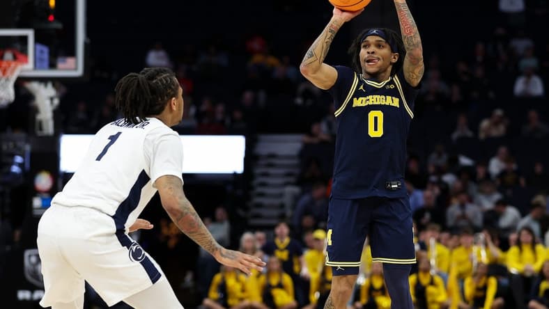 Mar 13, 2024; Minneapolis, MN, USA; Michigan Wolverines guard Dug McDaniel (0) shoots as Penn State Nittany Lions guard Ace Baldwin Jr. (1) defends during the first half at Target Center. Mandatory Credit: Matt Krohn-USA TODAY Sports