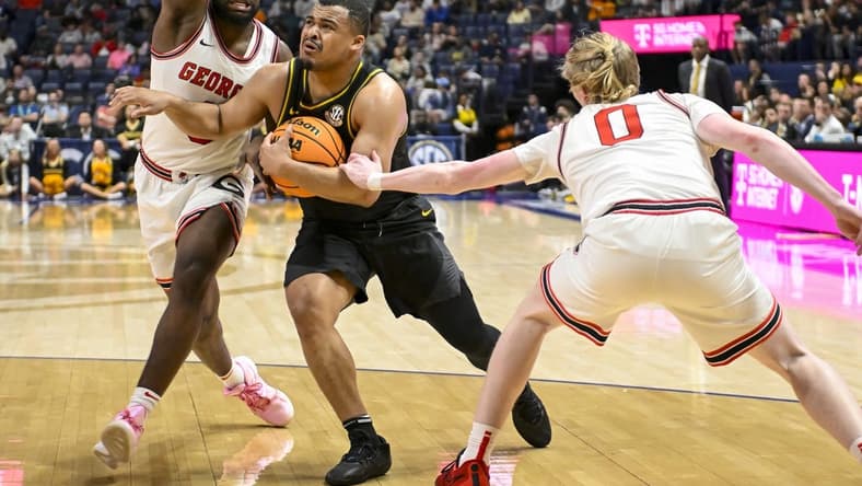 Mar 13, 2024; Nashville, TN, USA; Missouri Tigers guard Nick Honor (10) splits Georgia Bulldogs guard Blue Cain (0) and forward Jalen DeLoach (23) during the first half at Bridgestone Arena. Mandatory Credit: Steve Roberts-USA TODAY Sports