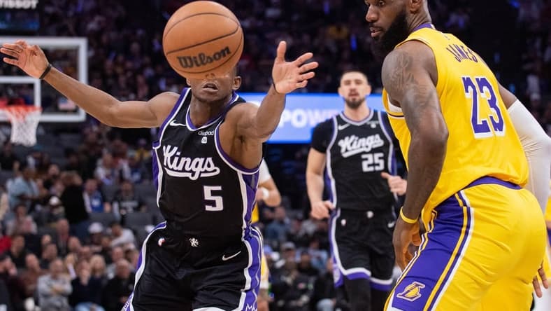Mar 13, 2024; Sacramento, California, USA; Sacramento Kings guard De'Aaron Fox (5) and Los Angeles Lakers forward LeBron James (23) go for the loose ball during the second quarter at Golden 1 Center. Mandatory Credit: Ed Szczepanski-USA TODAY Sports