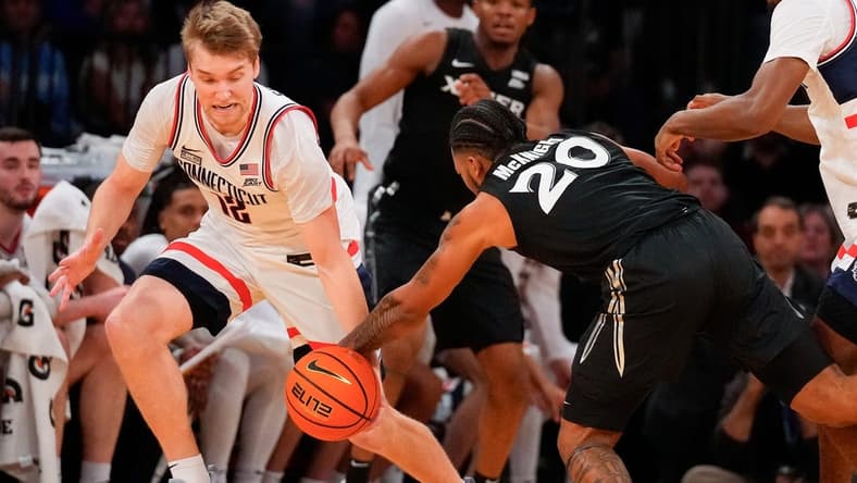 Mar 14, 2024; New York City, NY, USA; Connecticut Huskies guard Cam Spencer (12) steals the ball from Xavier Musketeers guard Dayvion McKnight (20) during the first half at Madison Square Garden. Mandatory Credit: Robert Deutsch-USA TODAY Sports