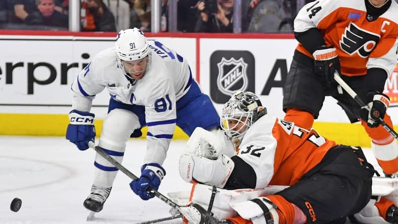 Mar 14, 2024; Philadelphia, Pennsylvania, USA; Philadelphia Flyers goaltender Felix Sandstrom (32) makes a save against Toronto Maple Leafs center John Tavares (91) during the second period at Wells Fargo Center. Mandatory Credit: Eric Hartline-USA TODAY Sports