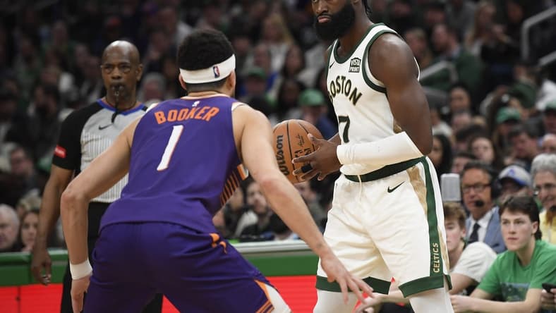 Mar 14, 2024; Boston, Massachusetts, USA; Boston Celtics guard Jaylen Brown (7) controls the ball while Phoenix Suns guard Devin Booker (1) defends during the second half at TD Garden. Mandatory Credit: Bob DeChiara-USA TODAY Sports
