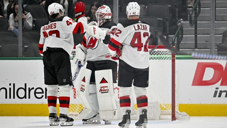 Mar 14, 2024; Dallas, Texas, USA; New Jersey Devils defenseman Luke Hughes (43) and center Curtis Lazar (42) and goaltender Jake Allen (34) celebrate on the ice after the Devils defeat the Dallas Stars at the American Airlines Center. Mandatory Credit: Jerome Miron-USA TODAY Sports