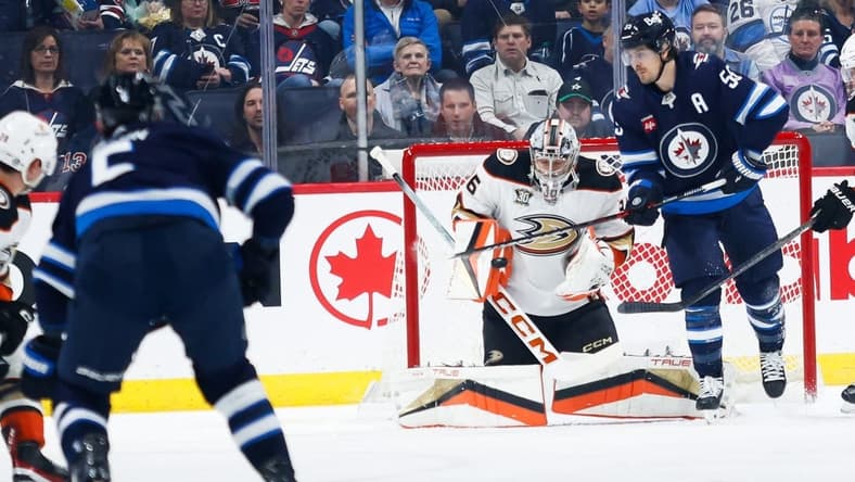 Mar 15, 2024; Winnipeg, Manitoba, CAN; Anaheim Ducks goalie John Gibson (36) makes a save on a shot by Winnipeg Jets defenseman Dylan DeMelo (2) during the first period at Canada Life Centre. Mandatory Credit: Terrence Lee-USA TODAY Sports