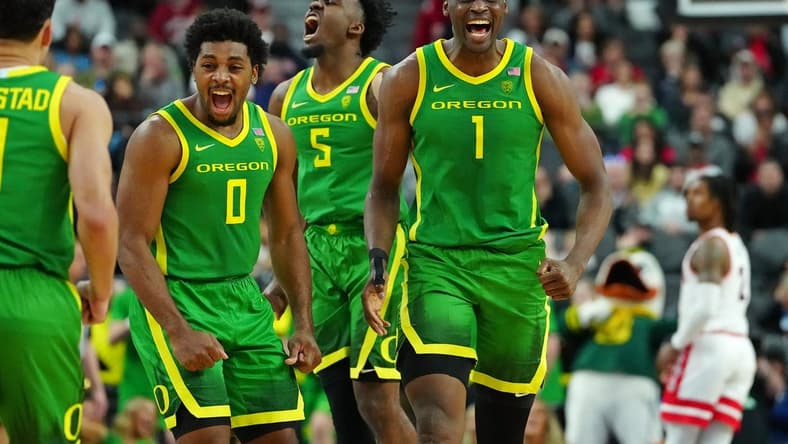 Mar 15, 2024; Las Vegas, NV, USA; Oregon Ducks center N'Faly Dante (1) celebrates with Oregon Ducks guard Kario Oquendo (0), and Oregon Ducks guard Jermaine Couisnard (5) after making a play against the Arizona Wildcats during the second half at T-Mobile Arena. Mandatory Credit: Stephen R. Sylvanie-USA TODAY Sports