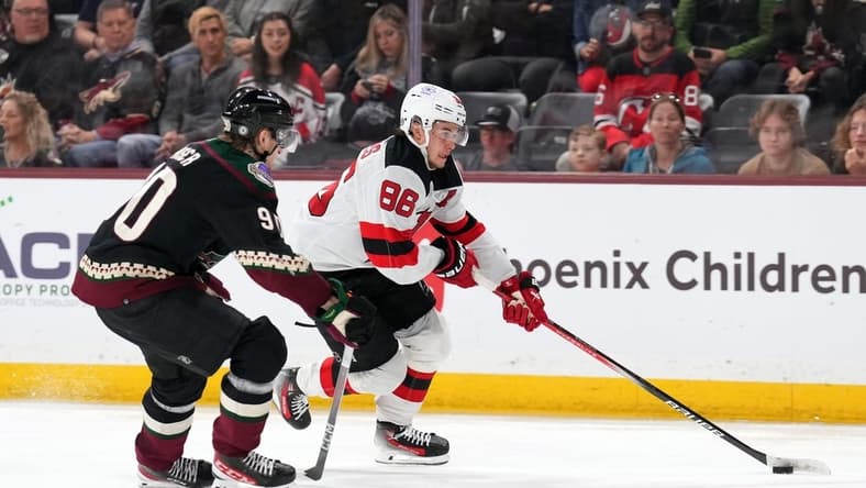 Mar 16, 2024; Tempe, Arizona, USA; New Jersey Devils center Jack Hughes (86) skates against Arizona Coyotes defenseman J.J. Moser (90) during the third period at Mullett Arena. Mandatory Credit: Joe Camporeale-USA TODAY Sports