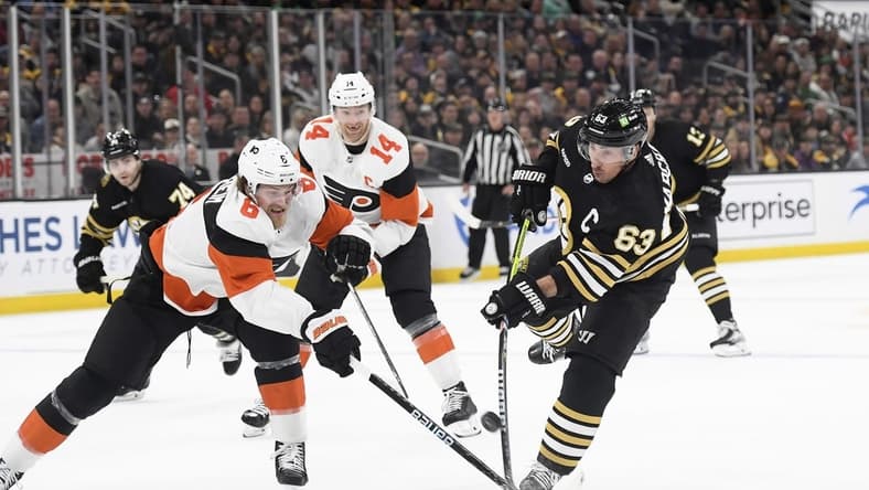 Mar 16, 2024; Boston, Massachusetts, USA; Boston Bruins left wing Brad Marchand (63) shoots the puck while Philadelphia Flyers defenseman Travis Sanheim (6) defends during the first period at TD Garden. Mandatory Credit: Bob DeChiara-USA TODAY Sports