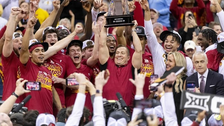 Mar 16, 2024; Kansas City, MO, USA; Iowa State Cyclones head coach TJ Otzelberger hoists the Big 12 Tournament trophy alongside his team after defeating the Houston Cougars at T-Mobile Center. Mandatory Credit: Amy Kontras-USA TODAY Sports