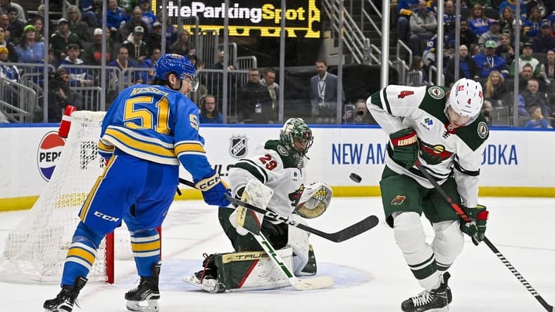Mar 16, 2024; St. Louis, Missouri, USA;  Minnesota Wild goaltender Marc-Andre Fleury (29) and defenseman Jon Merrill (4) defend the net against St. Louis Blues defenseman Matthew Kessel (51) during the second period at Enterprise Center. Mandatory Credit: Jeff Curry-USA TODAY Sports