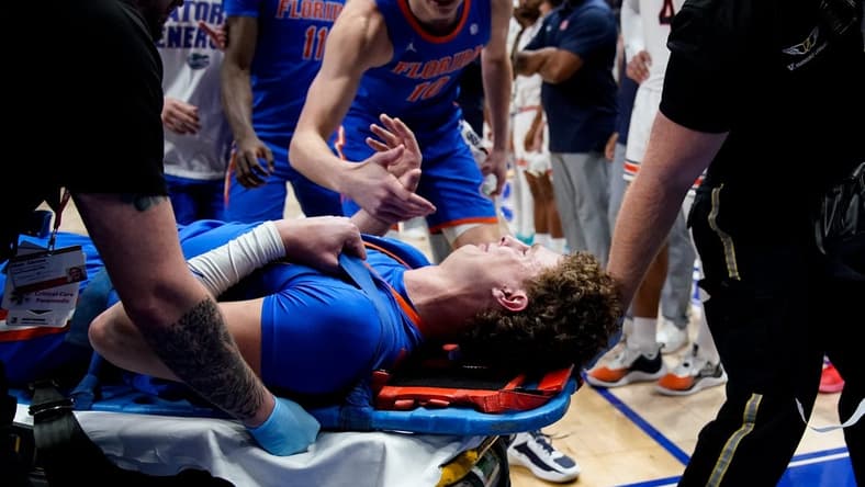 Florida center Micah Handlogten (3) is tended to after an injury during the first half of the SEC tournament championship game against Auburn at Bridgestone Arena in Nashville, Tenn., Sunday, March 17, 2024.