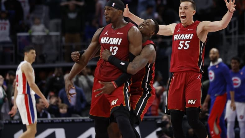 Mar 17, 2024; Detroit, Michigan, USA;  Miami Heat center Bam Adebayo (13) celebrates with guard Terry Rozier (2) and forward Duncan Robinson (55) after he hits a three point basket as time ran out to win the game against the Detroit Pistons at Little Caesars Arena. Mandatory Credit: Rick Osentoski-USA TODAY Sports