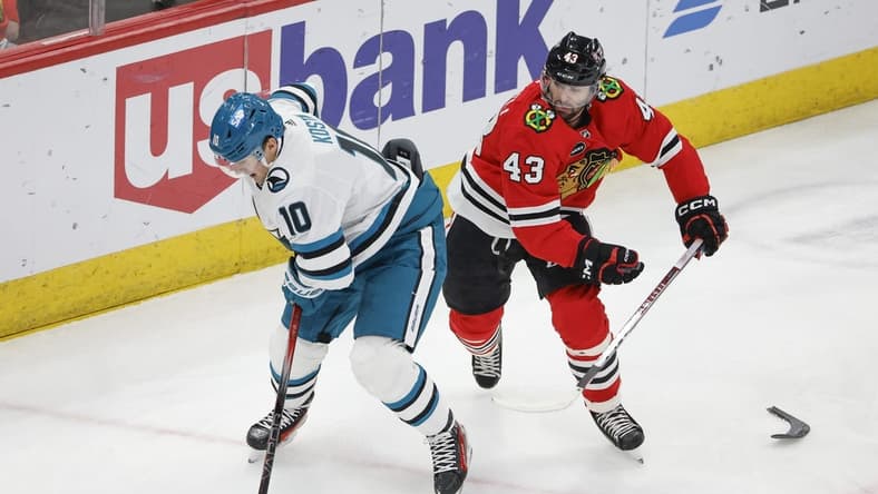Mar 17, 2024; Chicago, Illinois, USA; San Jose Sharks center Klim Kostin (10) keeps the puck away from Chicago Blackhawks center Colin Blackwell (43) during the first period at United Center. Mandatory Credit: Kamil Krzaczynski-USA TODAY Sports