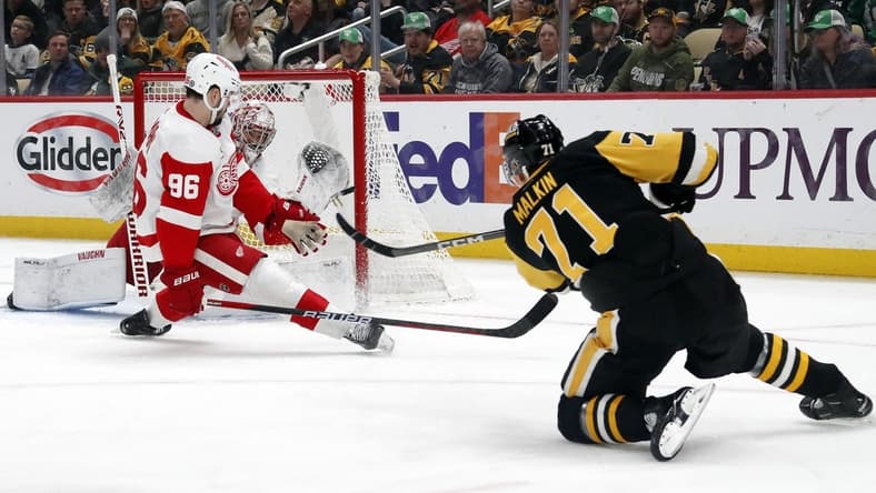 Mar 17, 2024; Pittsburgh, Pennsylvania, USA;  Detroit Red Wings goaltender Alex Lyon (rear) makes a glove save against Pittsburgh Penguins center Evgeni Malkin (71) as Detroit defenseman Jake Walman (96) defends during the first period at PPG Paints Arena. Mandatory Credit: Charles LeClaire-USA TODAY Sports