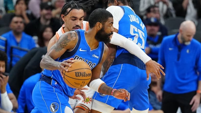 Mar 19, 2024; San Antonio, Texas, USA;  Dallas Mavericks guard Kyrie Irving (11) dribbles past San Antonio Spurs guard Tre Jones (33) in the first half at Frost Bank Center. Mandatory Credit: Daniel Dunn-USA TODAY Sports