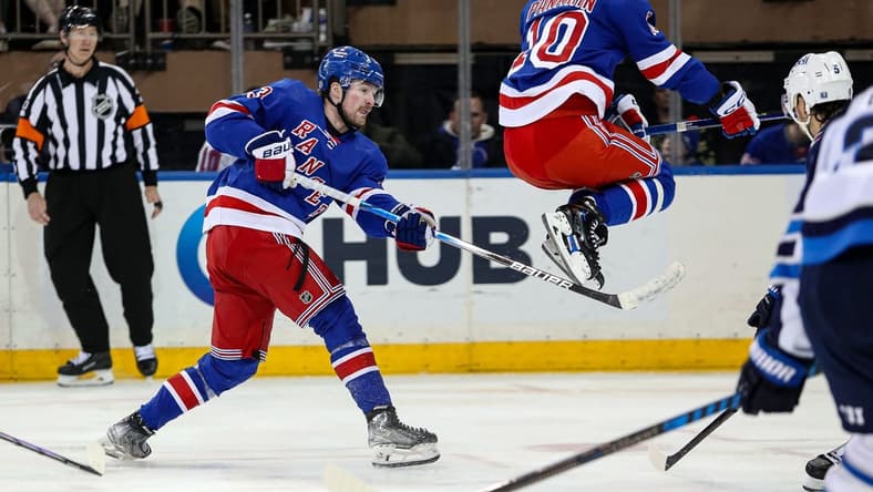 Mar 19, 2024; New York, New York, USA; New York Rangers left wing Artemi Panarin (10) jumps over a shot by New York Rangers forward Alexis Lafreniere (13) during the third period against the Winnipeg Jets at Madison Square Garden. Mandatory Credit: Danny Wild-USA TODAY Sports