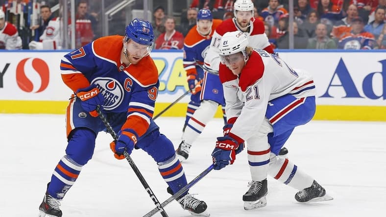 Mar 16, 2024; Edmonton, Alberta, CAN; Edmonton Oilers forward Connor McDavid (97) tries to carry the puck around Montreal Canadiens defensemen Kaiden Guhle (21) during the first period at Rogers Place. Mandatory Credit: Perry Nelson-USA TODAY Sports