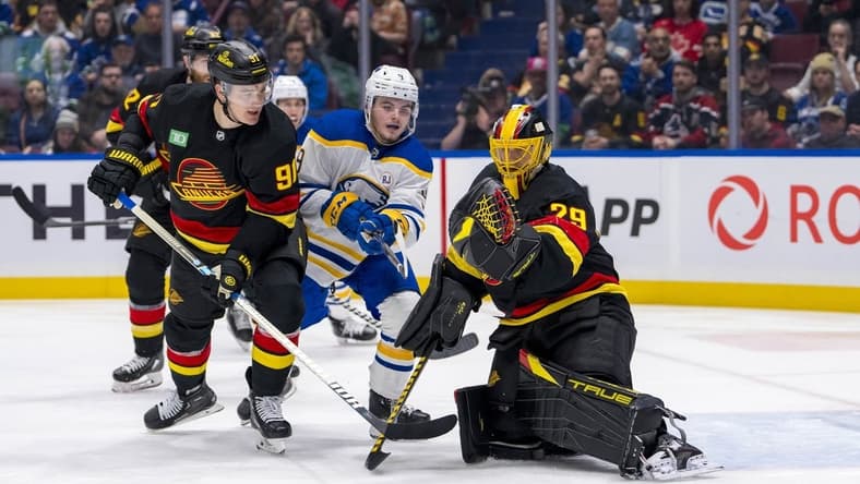 Mar 19, 2024; Vancouver, British Columbia, CAN; Vancouver Canucks defenseman Nikita Zadorov (91) and Buffalo Sabres forward Zach Benson (9) watch as goalie Casey DeSmith (29) makes a save in the second period at Rogers Arena. Mandatory Credit: Bob Frid-USA TODAY Sports