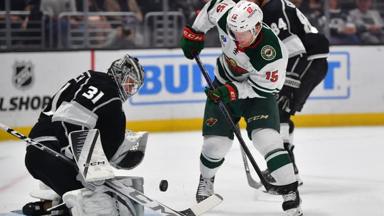 Mar 20, 2024; Los Angeles, California, USA; Los Angeles Kings goaltender David Rittich (31) blocks a shot against Minnesota Wild center Mason Shaw (15) during the first period at Crypto.com Arena. Mandatory Credit: Gary A. Vasquez-USA TODAY Sports