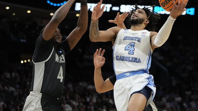 March 21, 2024, Charlotte, NC, USA; North Carolina Tar Heels guard RJ Davis (4) shoots against Wagner Seahawks forward Tyje Kelton (4) in the first round of the 2024 NCAA Tournament at the Spectrum Center. Mandatory Credit: Bob Donnan-USA TODAY Sports