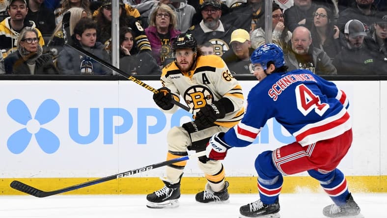 Mar 21, 2024; Boston, Massachusetts, USA; Boston Bruins right wing David Pastrnak (88) shoots the puck in front of New York Rangers defenseman Braden Schneider (4) during the first period at the TD Garden. Mandatory Credit: Brian Fluharty-USA TODAY Sports
