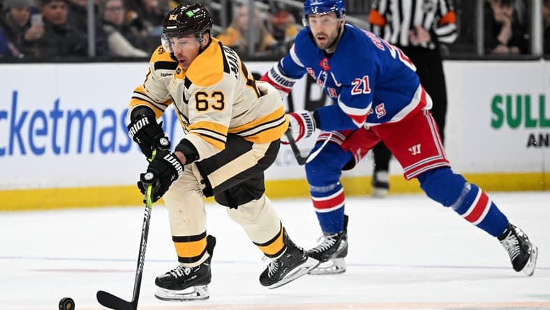 Mar 21, 2024; Boston, Massachusetts, USA; Boston Bruins left wing Brad Marchand (63) skates with the puck against New York Rangers center Barclay Goodrow (21) during the second period at the TD Garden. Mandatory Credit: Brian Fluharty-USA TODAY Sports