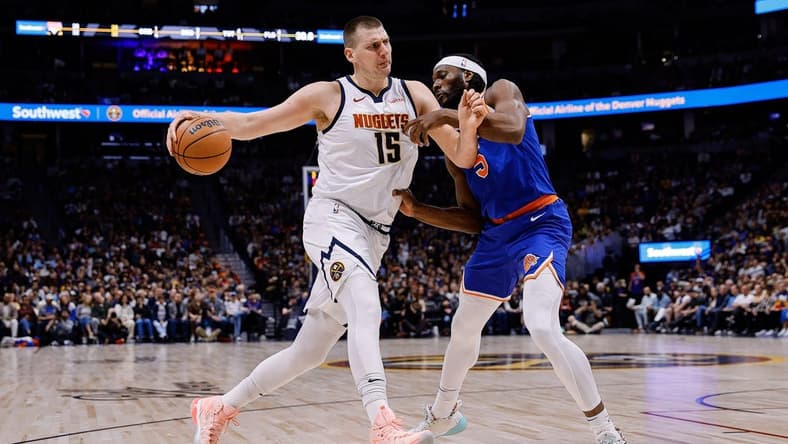 Mar 21, 2024; Denver, Colorado, USA; Denver Nuggets center Nikola Jokic (15) controls the ball as New York Knicks forward Precious Achiuwa (5) guards in the first quarter at Ball Arena. Mandatory Credit: Isaiah J. Downing-USA TODAY Sports