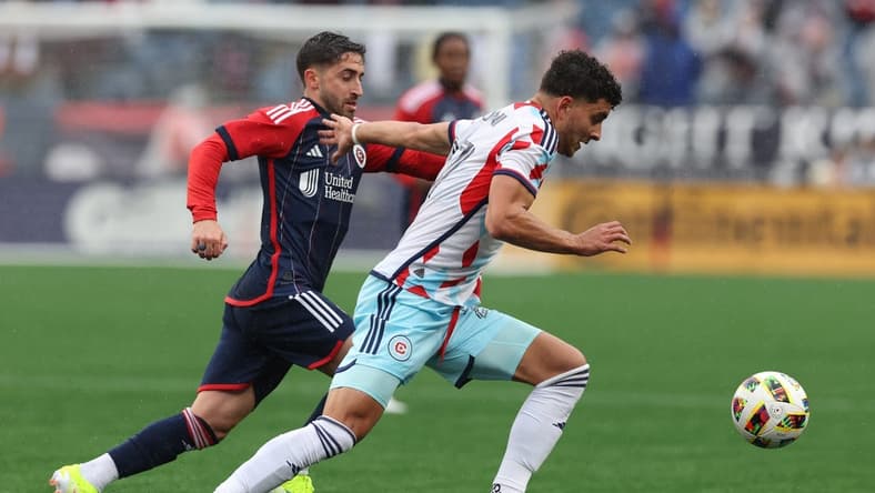 Mar 23, 2024; Foxborough, Massachusetts, USA; Chicago Fire FC defender Allan Arigoni (27) plays the ball defended by New England Revolution midfielder Nacho Gil (21) in the first half at Gillette Stadium. Mandatory Credit: Paul Rutherford-USA TODAY Sports
