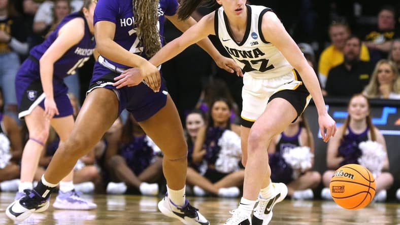 Iowa's Caitlin Clark dribbles as Holy Cross' Simone Foreman defends in a first-round NCAA Tournament game on Saturday.