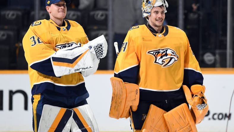 Mar 23, 2024; Nashville, Tennessee, USA; Nashville Predators goaltender Kevin Lankinen (32) and goaltender Juuse Saros (74) skate after a win against the Detroit Red Wings at Bridgestone Arena. Mandatory Credit: Christopher Hanewinckel-USA TODAY Sports