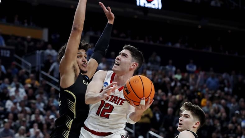 Mar 23, 2024; Pittsburgh, PA, USA; North Carolina State Wolfpack guard Michael O'Connell (12) shoots the ball against Oakland Golden Grizzlies forward Trey Townsend (4) during the second half in the second round of the 2024 NCAA Tournament at PPG Paints Arena. Mandatory Credit: Charles LeClaire-USA TODAY Sports
