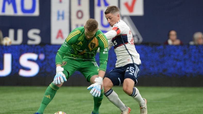Mar 23, 2024; Vancouver, British Columbia, CAN;  Real Salt Lake goalkeeper Zac MacMath (18) defends against Vancouver Whitecaps FC midfielder Ryan Gauld (25) during the second half at BC Place. Mandatory Credit: Anne-Marie Sorvin-USA TODAY Sports