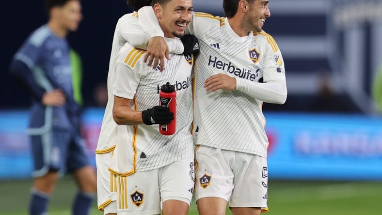Mar 23, 2024; Kansas City, Kansas, USA; LA Galaxy midfielder Mark Delgado (8) and midfielder Gaston Brugman (5) celebrate after a Galaxy goal against Sporting Kansas City during the second half at Children's Mercy Park. Mandatory Credit: William Purnell-USA TODAY Sports