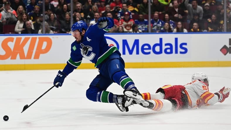 Mar 23, 2024; Vancouver, British Columbia, CAN; Vancouver Canucks forward J.T. Miller (9) checked by Calgary Flames defenseman Olivver Kylington (58) during the third period at Rogers Arena. Mandatory Credit: Simon Fearn-USA TODAY Sports