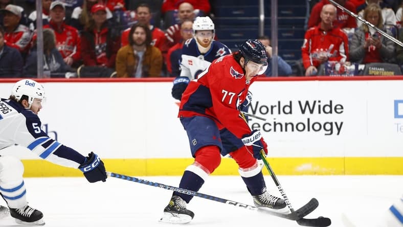 Mar 24, 2024; Washington, District of Columbia, USA; Washington Capitals right wing T.J. Oshie (77) controls the puck as Winnipeg Jets defenseman Dylan Samberg (54) defends during the first period at Capital One Arena. Mandatory Credit: Amber Searls-USA TODAY Sports