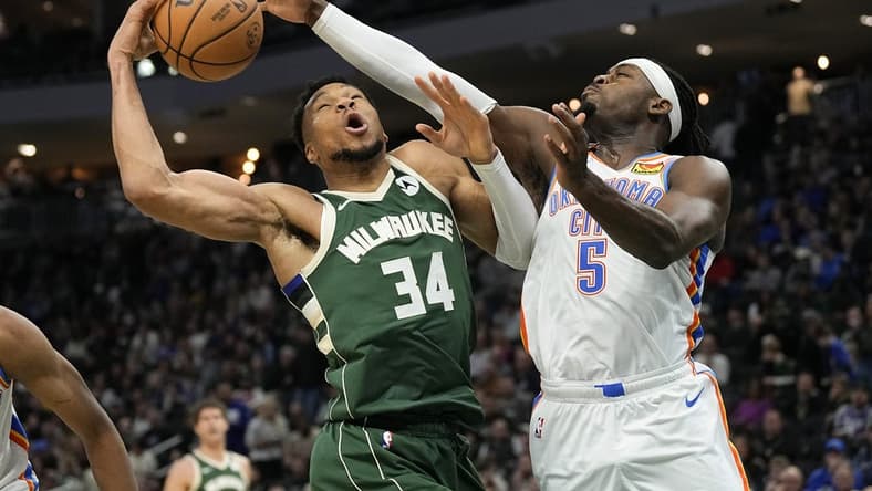 Mar 24, 2024; Milwaukee, Wisconsin, USA;  Milwaukee Bucks forward Giannis Antetokounmpo (34) and Oklahoma City Thunder forward Luguentz Dort (5) reach for a rebound during the third quarter at Fiserv Forum. Mandatory Credit: Jeff Hanisch-USA TODAY Sports