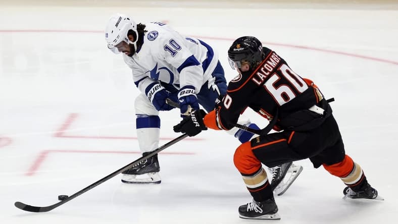 Mar 24, 2024; Anaheim, California, USA; Tampa Bay Lightning left wing Anthony Duclair (10) and Anaheim Ducks defenseman Jackson LaCombe (60) chase the puck during the third period at Honda Center. Mandatory Credit: Jason Parkhurst-USA TODAY Sports