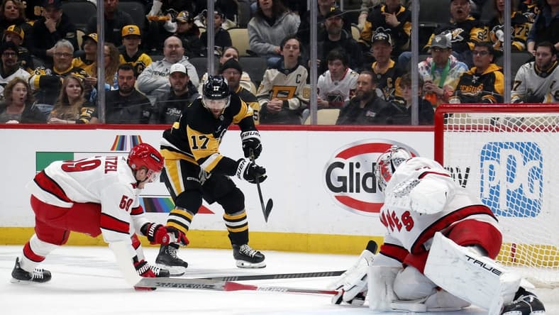 Mar 26, 2024; Pittsburgh, Pennsylvania, USA; Carolina Hurricanes left wing Jake Guentzel (59) and goaltender Pyotr Kochetkov (52) defend Pittsburgh Penguins right wing Bryan Rust (17) during the first period at PPG Paints Arena. Mandatory Credit: Charles LeClaire-USA TODAY Sports