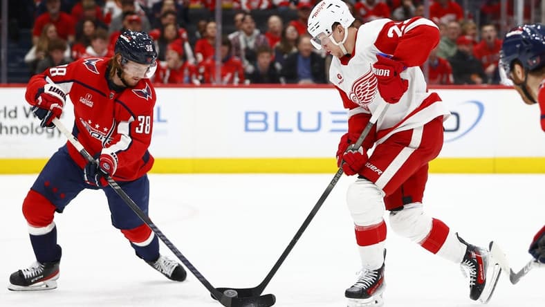 Mar 26, 2024; Washington, District of Columbia, USA; Detroit Red Wings left wing Lucas Raymond (23) battles for the puck with Washington Capitals defenseman Rasmus Sandin (38) during the second period at Capital One Arena. Mandatory Credit: Amber Searls-USA TODAY Sports