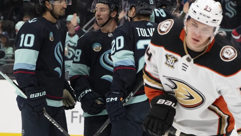 Mar 26, 2024; Seattle, Washington, USA; sSeattle Kraken players icnlduing forward Matty Beniers (10), forward Logan Morrison (59), second from left, and forward Eeli Tolvanen (20) celebrate a goald during the second period against the Anaheim Ducks gat Climate Pledge Arena. Mandatory Credit: Stephen Brashear-USA TODAY Sports