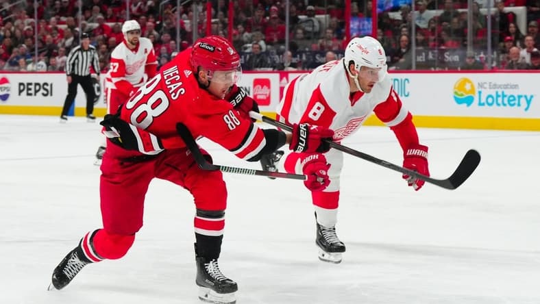 Mar 28, 2024; Raleigh, North Carolina, USA; Carolina Hurricanes center Martin Necas (88) gets the shot past Detroit Red Wings defenseman Ben Chiarot (8) during the second period at PNC Arena. Mandatory Credit: James Guillory-USA TODAY Sports