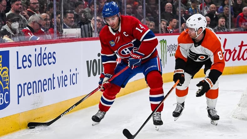 Mar 28, 2024; Montreal, Quebec, CAN; Montreal Canadiens center Nick Suzuki (14) plays the puck against Philadelphia Flyers defenseman Cam York (8) during the second period at Bell Centre. Mandatory Credit: David Kirouac-USA TODAY Sports