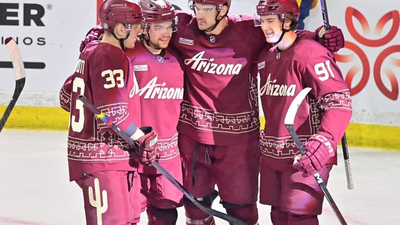 Mar 28, 2024; Tempe, Arizona, USA; Arizona Coyotes center Jack McBain (22) celebrates with right wing Josh Doan (91), left wing Matias Maccelli (63) and defenseman Travis Dermott (33) after scoring a goal in the first period against the Nashville Predators at Mullett Arena. Mandatory Credit: Matt Kartozian-USA TODAY Sports