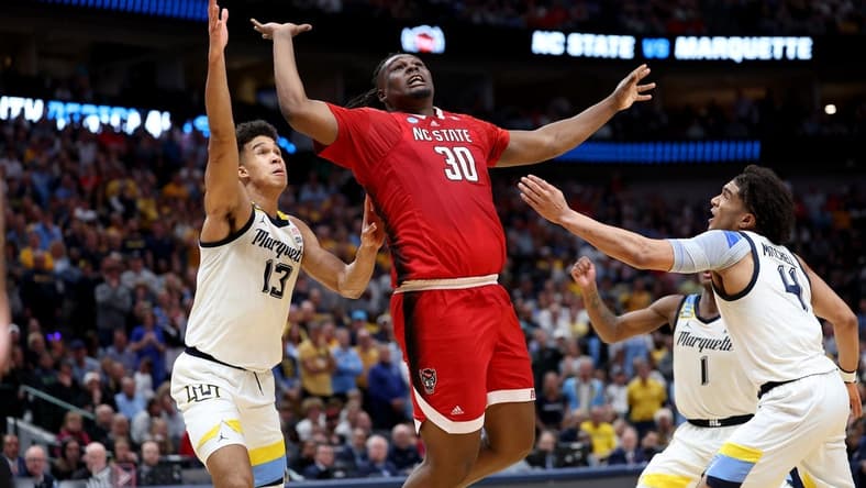 Mar 29, 2024; Dallas, TX, USA; North Carolina State Wolfpack forward DJ Burns Jr. (30) rebounds against Marquette Golden Eagles forward Oso Ighodaro (13), guard Kam Jones (1) and guard Stevie Mitchell (4) during the second half in the semifinals of the South Regional of the 2024 NCAA Tournament at American Airlines Center. Mandatory Credit: Kevin Jairaj-USA TODAY Sports