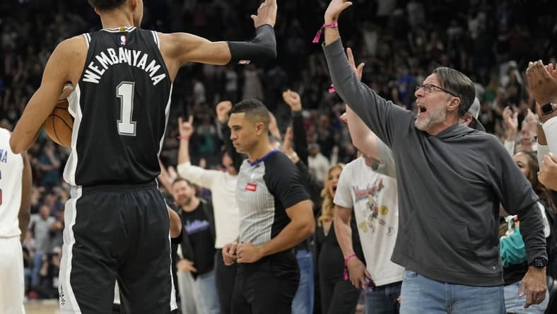 Mar 29, 2024; San Antonio, Texas, USA; San Antonio Spurs forward Victor Wembanyama (1) and a fan react after an overtime victory over the New York Knicks at Frost Bank Center. Mandatory Credit: Scott Wachter-USA TODAY Sports