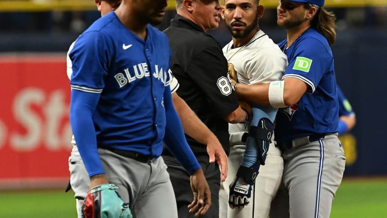 Mar 30, 2024; St. Petersburg, Florida, USA; Tampa Bay Rays shortstop Jose Caballero (7) stares at Toronto Blue Jays relief pitcher Genesis Cabrera (92) after they collide in the seventh inning of the game at Tropicana Field. Mandatory Credit: Jonathan Dyer-USA TODAY Sports