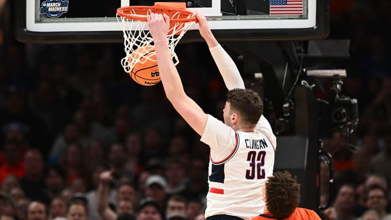 Mar 30, 2024; Boston, MA, USA; Connecticut Huskies center Donovan Clingan (32) dunks the ball against Illinois Fighting Illini forward Coleman Hawkins (33) in the finals of the East Regional of the 2024 NCAA Tournament at TD Garden. Mandatory Credit: Brian Fluharty-USA TODAY Sports