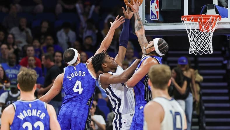 Mar 30, 2024; Orlando, Florida, USA; Orlando Magic forward Paolo Banchero (5) and guard Jalen Suggs (4) block a shot attempt by Memphis Grizzlies forward GG Jackson (45) during the first quarter at KIA Center. Mandatory Credit: Mike Watters-USA TODAY Sports