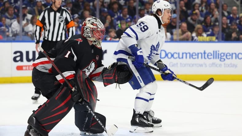 Mar 30, 2024; Buffalo, New York, USA; Buffalo Sabres goaltender Ukko-Pekka Luukkonen (1) and Toronto Maple Leafs left wing Tyler Bertuzzi (59) look for the puck during the first period at KeyBank Center. Mandatory Credit: Timothy T. Ludwig-USA TODAY Sports
